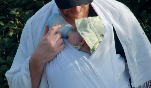 Bära en nyfödd bebis i bärsjal. Flaskmatning i bärsjal.