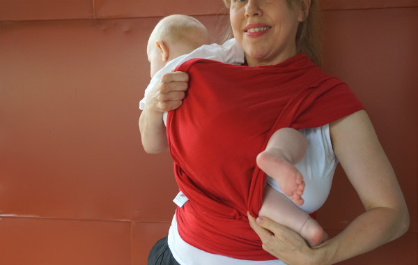 Bildserie: Amma i trikåsjal. Bebis ligger lite på sniskan i röd bärsjal.