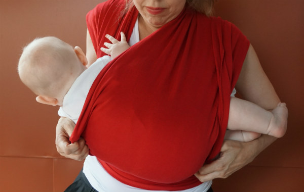 Bildserie: Amma i trikåsjal. Bebis läggs ned på sidan i röd bärsjal.