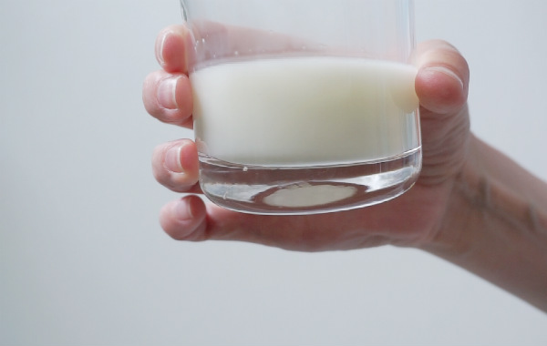 Handmjölkning. Glas med bröstmjölk.