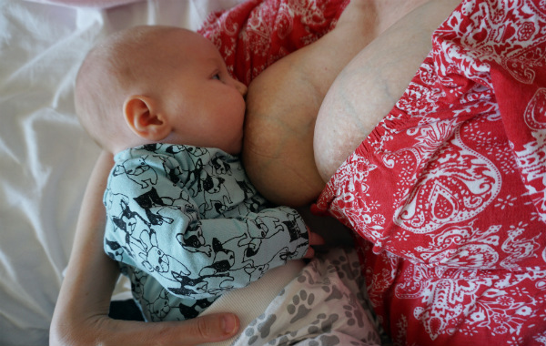 Personligt om samsovning. Bebis ligger på mammas arm och ammar.