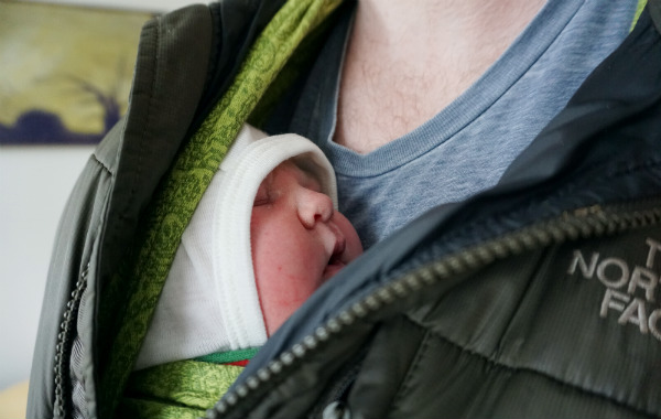 Bärsjal på BB. Alldeles nyfödd bebis i bärsjal på pappas bröst.