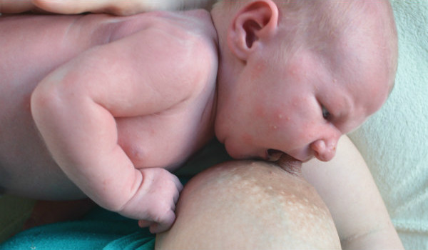 Amningsdagbok del tre. Nyfödd bebis gapar stort om bröstet vid amning.