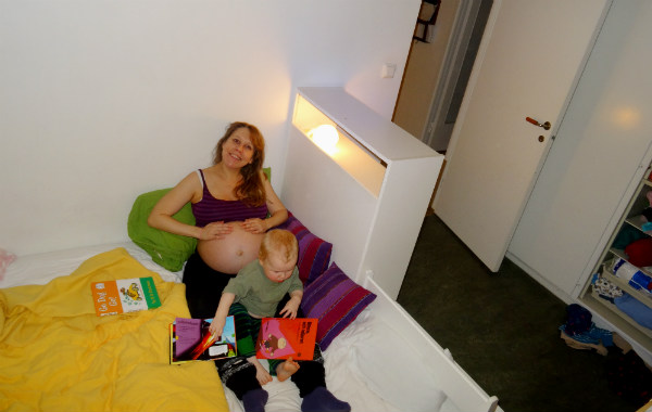 Amningsdagbok del ett. Gravid kvinna i sängen med litet barn.