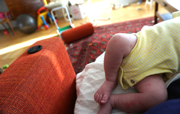 Amningsdagbok del tre. Ben på bebis som ligger i soffa.