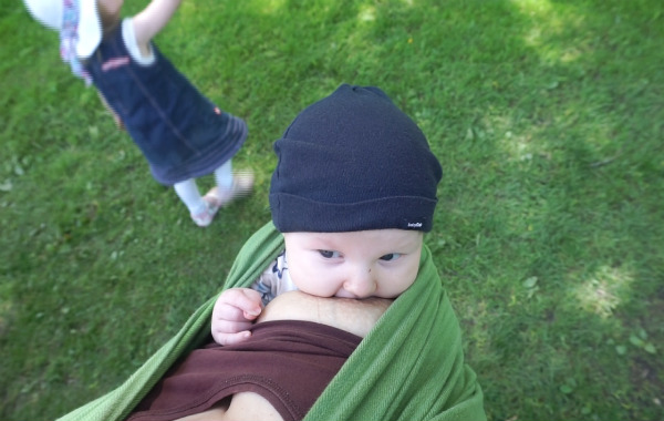 Tips om hur du ammar i bärsele och bärsjal, bebis ammar i grön bärsjal utomhus, vid gräsmatta, sommar.