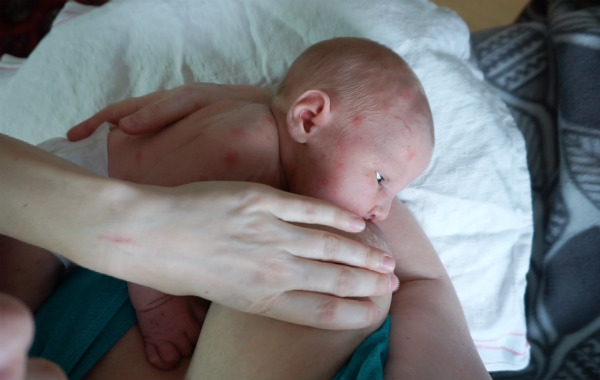 Video om aktiv amning, bröstkompressioner. Han klämmer åt om bröst medan nyfödd ammar.