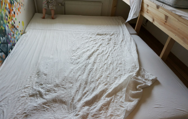 Säng för samsovning. Madrasskydd ligger över nästan hela sängen.